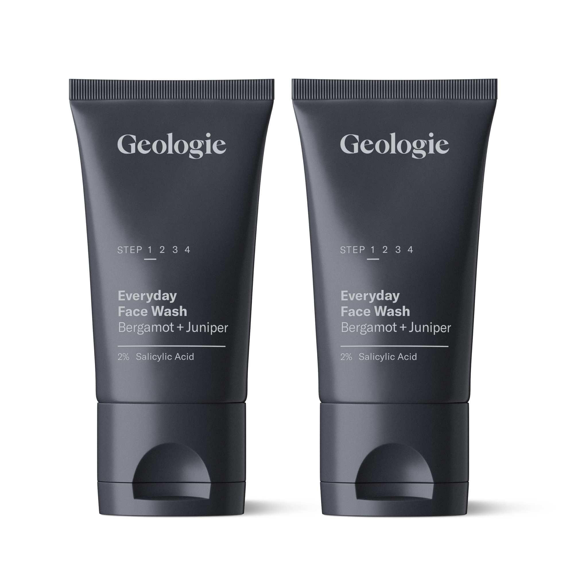 Two tubes of Geologie Salicylic Acid Face Wash with labels for everyday face wash bergamot + juniper and 2% salicylic acid, standing upright on a reflective surface.